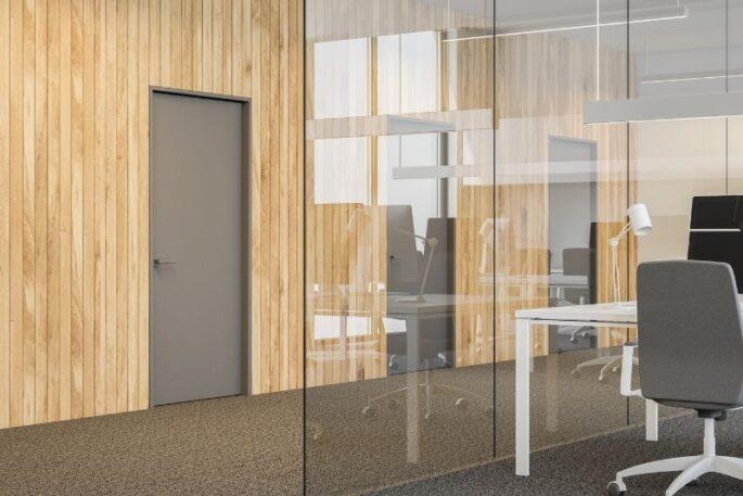 Modern office with vertical timber slat wall paneling, glass partition, and flush grey door