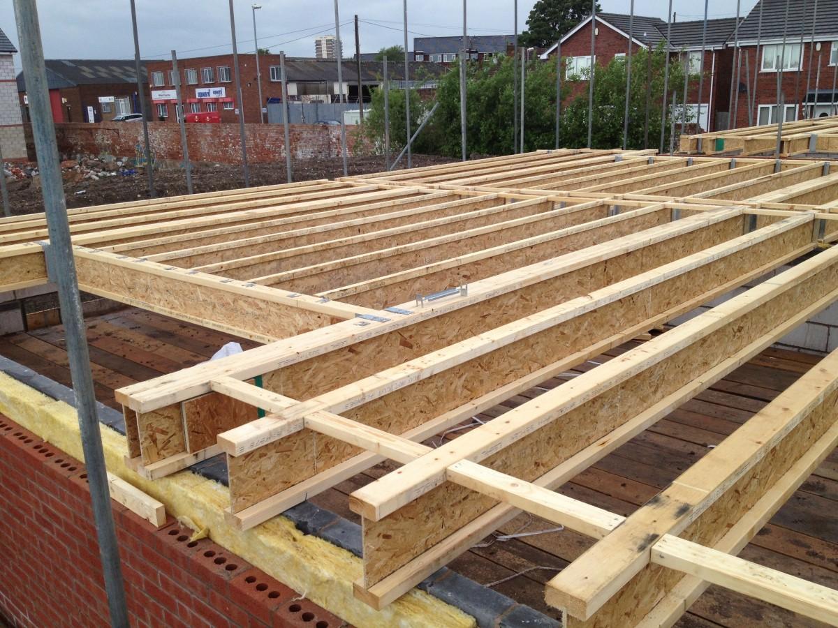 New-build roof deck — timber joists and OSB sheeting viewed from scaffold level