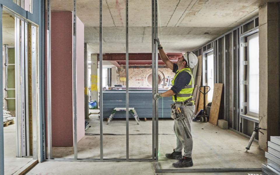 Operative in hard hat fitting metal stud track to a concrete soffit
