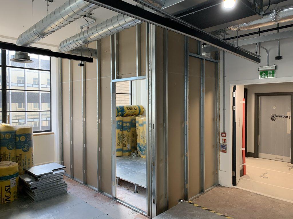 Commercial fit-out in progress — metal stud framing with Rockwool insulation packs, London office site